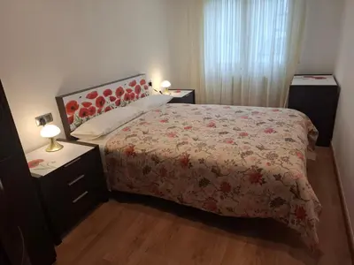 a bedroom with a bed with a floral bedspread at Apartamento Lugo Muralla in Lugo