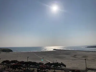 a beach with a view of the ocean and the sun at En Foz en 1a línea de playa in Foz