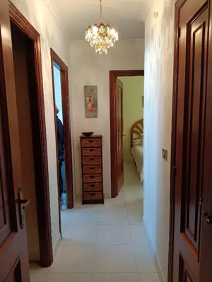 a hallway with a dresser and a chandelier at En Foz en 1a línea de playa in Foz