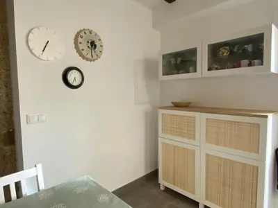 a dining room with clocks on the wall and a dresser at A CASIÑA dos LARANXOS in Cenlle