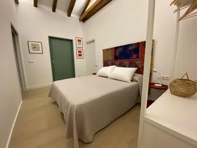 a bedroom with a bed and a green door at A CASIÑA dos LARANXOS in Cenlle