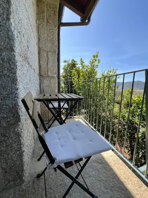 a chair sitting on a balcony with a table at A CASIÑA dos LARANXOS in Cenlle