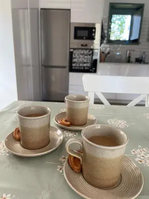 two cups of coffee sitting on plates on a table at A CASIÑA dos LARANXOS in Cenlle