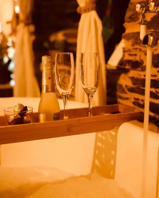 two wine glasses and a bottle on a wooden shelf at Casa Da Fragua in Samos