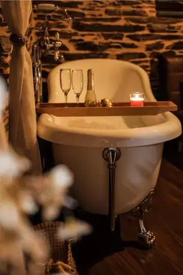 a bathroom with a bath tub with two wine glasses at Casa Da Fragua in Samos
