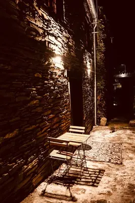 a bench sitting in front of a stone building at night at Casa Da Fragua in Samos