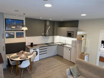 a kitchen and living room with a table and a couch at Pension Lugo FINGOI in Lugo
