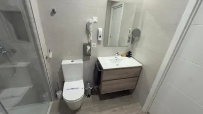 a bathroom with a toilet and a sink and a shower at Pension Lugo FINGOI in Lugo