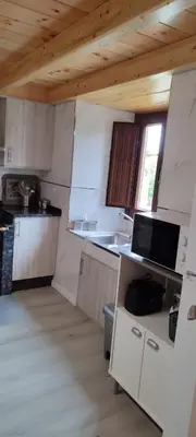 a kitchen with white appliances and a wooden ceiling at Costa A Mariña in Barreiros
