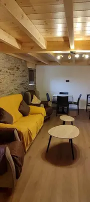 a living room with a yellow couch and a table at Costa A Mariña in Barreiros