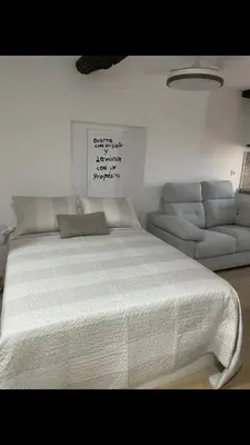 a bedroom with a large white bed and a couch at CASA CRISTINA Alojamiento céntrico en pleno casco histórico y centro de la ciudad in Monforte de Lemos