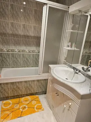 a bathroom with a sink and a shower and a tub at Luxurious downtown apartment in Ribadeo in Ribadeo