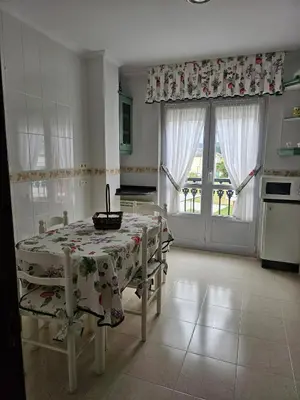 a kitchen with a table and chairs in a room at Luxurious downtown apartment in Ribadeo in Ribadeo