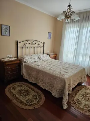 a bedroom with a bed and a dresser and a window at Luxurious downtown apartment in Ribadeo in Ribadeo