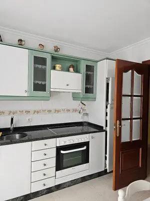 a kitchen with white appliances and green cabinets at Luxurious downtown apartment in Ribadeo in Ribadeo