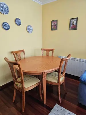 a wooden table with four chairs and plates on the wall at Luxurious downtown apartment in Ribadeo in Ribadeo