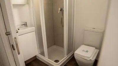 a bathroom with a shower and a toilet and a sink at Xeocámping Montañas do Courel