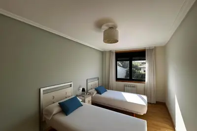 a hotel room with two beds and a window at Ribeira Sacra Suites in Nogueira de Ramuin