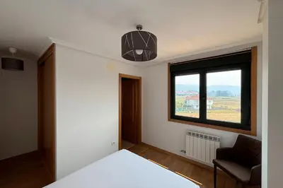 a bedroom with a bed and a window at Ribeira Sacra Suites in Nogueira de Ramuin