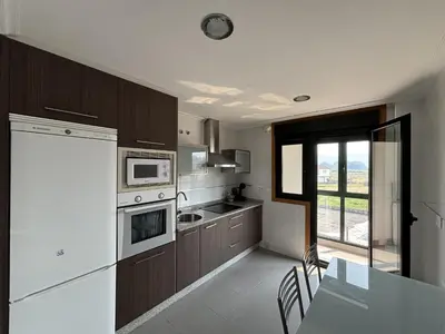 a kitchen with brown and white appliances and a table at Ribeira Sacra Suites in Nogueira de Ramuin