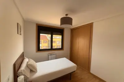 a small bedroom with a bed and a window at Ribeira Sacra Suites in Nogueira de Ramuin