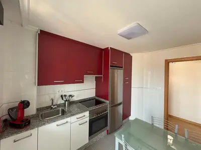a kitchen with red cabinets and a sink at Ribeira Sacra Suites in Nogueira de Ramuin