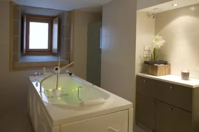 a bathroom with a tub with a window and a sink at Parador de Santo Estevo in Santo Estevo de Rivas de Sil