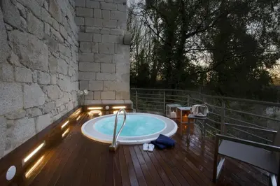 a jacuzzi tub on a wooden deck with lights at Parador de Santo Estevo in Santo Estevo de Rivas de Sil
