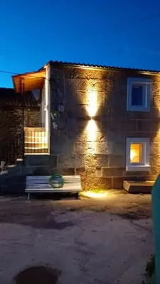 a bench in front of a stone building at night at Hermosa Casa en Ribeira Sacra in Sistín