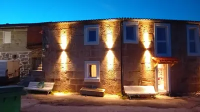 a brick house with lights on the side of it at Duplex en Ribeira Sacra in Sistín