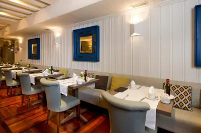 a dining room with tables and chairs in a restaurant at Parador de Santiago - Hostal Reis Catolicos in Santiago de Compostela
