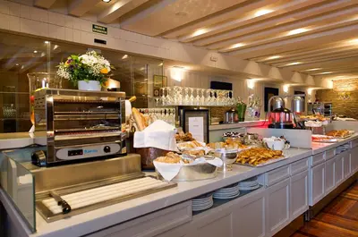 a buffet line in a restaurant with a lot of food at Parador de Santiago - Hostal Reis Catolicos in Santiago de Compostela
