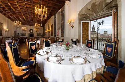 a dining room with a white table and chairs at Parador de Santiago - Hostal Reis Catolicos in Santiago de Compostela