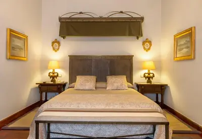 a bedroom with a large bed with two lamps at Parador de Santiago - Hostal Reis Catolicos in Santiago de Compostela