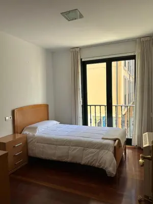 a bedroom with a bed and a large window at Piso Ría de Ribadeo in Ribadeo