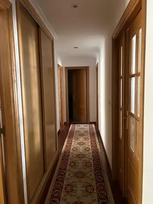 a hallway with a rug on the floor next to a door at Piso Ría de Ribadeo in Ribadeo