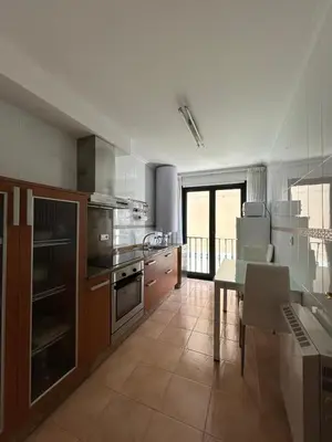 a kitchen with a table and a dining room at Piso Ría de Ribadeo in Ribadeo