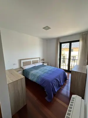 a bedroom with a bed and a large window at Piso Ría de Ribadeo in Ribadeo