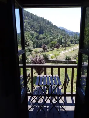 a view from a window of a table and chairs on a balcony at Hospedaje - Ferrería Quintá in Quiroga