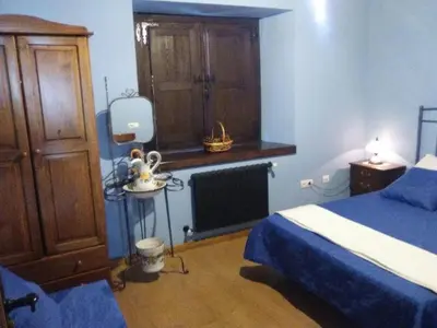a blue bedroom with a bed and a dresser at Hospedaje - Ferrería Quintá in Quiroga