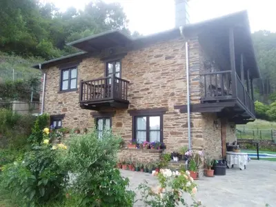 a brick house with two balconies on it at Hospedaje - Ferrería Quintá in Quiroga