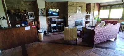a living room with two chairs and a fireplace at Casa mañoso in Cea