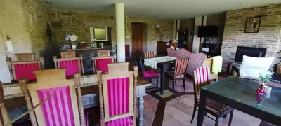 a room with chairs and tables and a fireplace at Casa mañoso in Cea