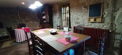 a wooden table in a room with a stone wall at Casa mañoso in Cea