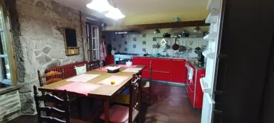 a kitchen with a wooden table and red cabinets at Casa mañoso in Cea