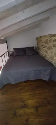 a bed in a bedroom with a wooden floor at O Recuncho do Lito