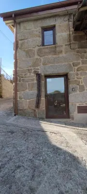 a stone building with a sign on the side of it at O Recuncho do Lito