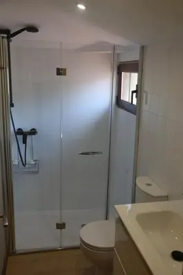 a bathroom with a shower and a toilet and a sink at O'Regueiro