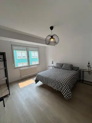 a white bedroom with a bed and two windows at Civitas Augusta in Lugo