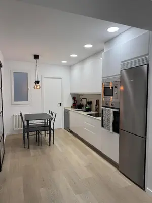a kitchen with a table with chairs and a refrigerator at Civitas Augusta in Lugo